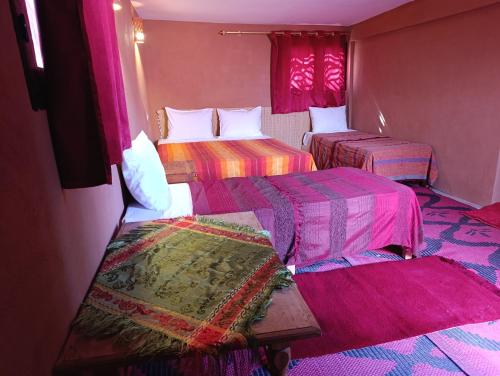 a room with two beds with colorful blankets at Bivouac Lot Of Stars in Ouarzazate