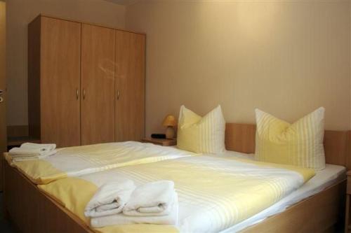 a bedroom with a large bed with towels on it at Apartmenthaus Am See in Rheinsberg