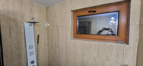 a person taking a picture of a mirror in a bathroom at Casa Cărbunaru in Tîrgu Ocna