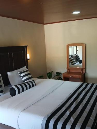 a bedroom with a large bed and a mirror at Green Peak - Mountain View Hotel & Restaurant in Ella