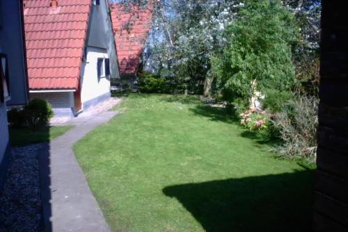 a yard with green grass next to a house at Haus Reiher Am Lauwersmeer in Anjum