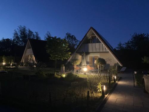 a house with lights in the yard at night at Haus Reiher Am Lauwersmeer in Anjum