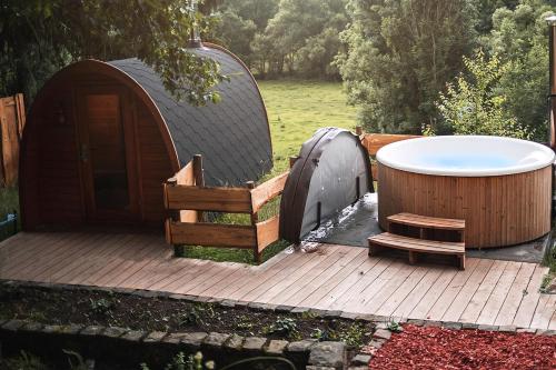 una vasca e un ponte in legno con una vasca idromassaggio e una panca in legno di Haus Für 22 Personen Mit Außensauna Und Hottub a Dahlem