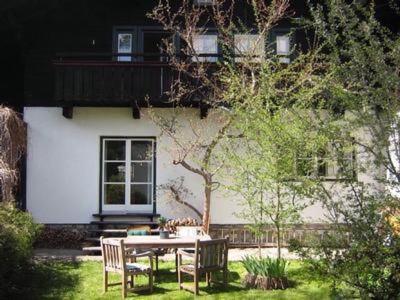 a table and chairs in front of a building at Gemütliches Ferienhaus In Lofer Mit Garten in Lofer