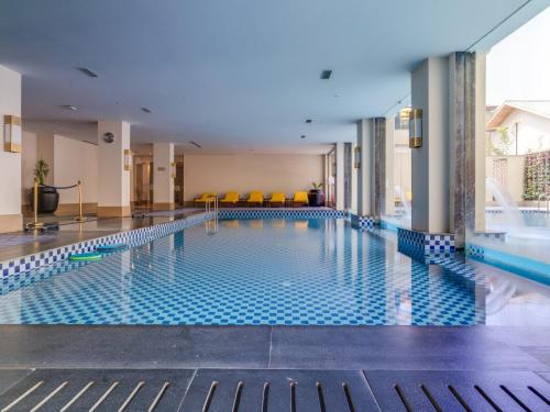 a swimming pool in a hotel with yellow chairs at Radisson Collection Hotel & Spa, Riverfront Srinagar in Srinagar