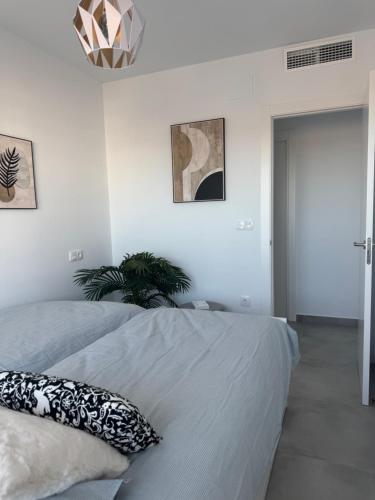 a bedroom with two beds and a potted plant at Santa Rosalía Lake and Life - INVBUILD ESTATES in Torre-Pacheco
