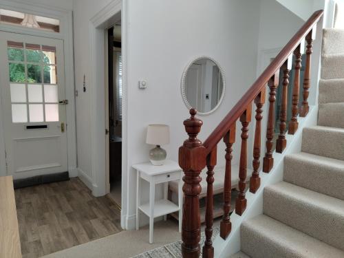 德里门Mulberry Lodge Guest Suite - luxurious accommodation on West Highland Way的走廊上设有楼梯,墙上有镜子