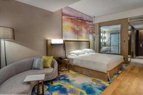 a hotel room with a bed and a couch at Crowne Plaza Beihai Silver Beach by IHG in Beihai