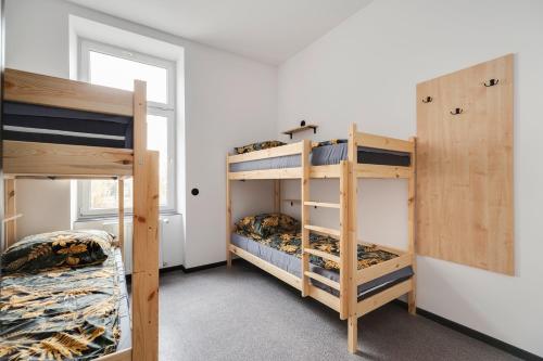 two bunk beds in a room with a window at Najtańsze noclegi Piłsudskiego 93 in Łódź