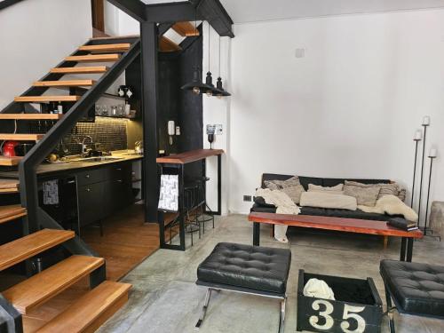 a living room with a staircase and a couch at Las Glicinas Boutique Apartments in Colonia del Sacramento