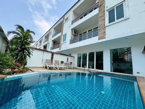 a swimming pool in front of a building at Hidden Palm Pool Villas in North Pattaya