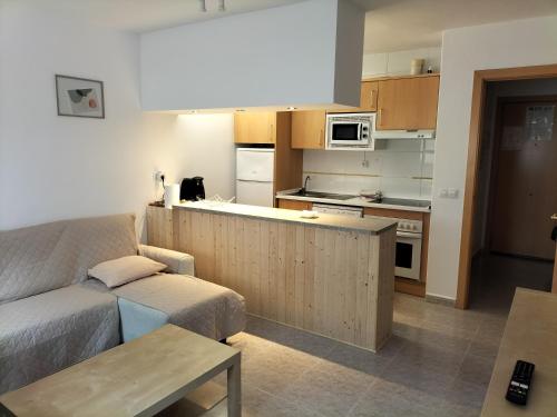 een woonkamer met een bank en een keuken bij Miami Platja cerca del mar in Miami Platja