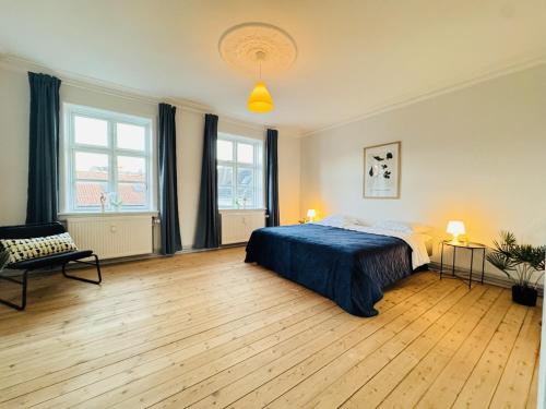 a bedroom with a bed and two windows at aday - Beautiful and Spacious 4 bedroom - Heart of Aalborg in Aalborg