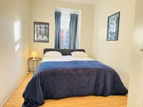 a bedroom with a large bed with a blue blanket at aday - Beautiful and Spacious 4 bedroom - Heart of Aalborg in Aalborg