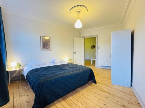 a bedroom with a bed with a blue comforter at aday - Beautiful and Spacious 4 bedroom - Heart of Aalborg in Aalborg