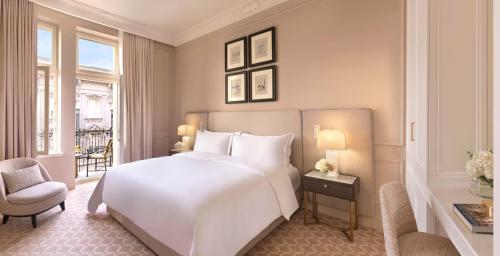 Un dormitorio con una gran cama blanca y una ventana. en The Bristol Belgrade, en Belgrado