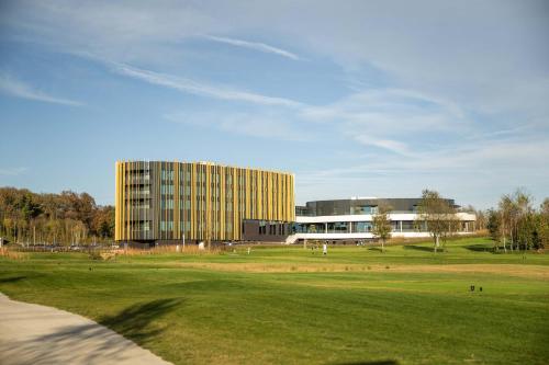 a large building in front of a green field at Hotel du Bois d'Arlon in Arlon