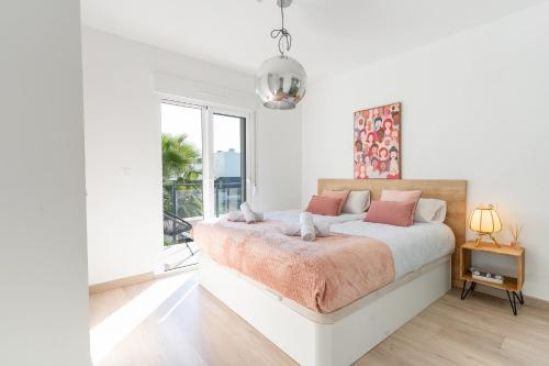 Un dormitorio blanco con una cama y una ventana grande. en Azure Escape Villa, Gran Alacant by United Renters, en Puerto Marino