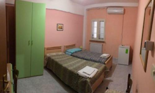 two beds in a room with green and pink walls at La Pergolina in Tolve