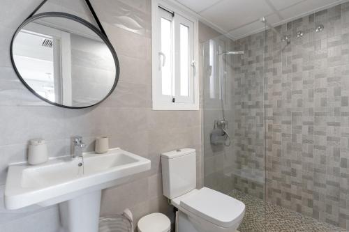 Un baño con inodoro, lavabo y espejo. en Azure Escape Villa, Gran Alacant by United Renters, en Puerto Marino