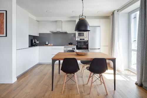 a kitchen with a wooden table and black chairs at H SUITE3A by Smiling Rentals in Hondarribia