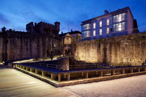 a building with a clock on the side of a wall at H SUITE3A by Smiling Rentals in Hondarribia