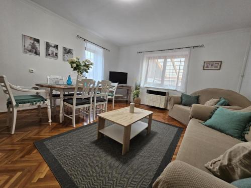 a living room with a couch and a table at Csobogós Vendégház Mályinka in Mályinka