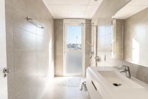 Un baño blanco con ducha y lavabo. en Villa Oasis del Sol Gran Alacant by United Renters, en Puerto Marino