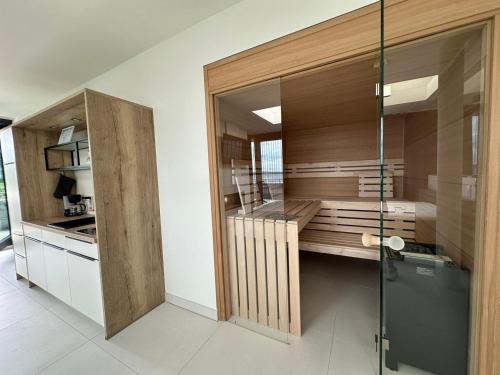 a kitchen with wooden cabinets and a glass wall at Hafen 15 - Ihre Ferienwohnung im Hafen am Geiseltalsee in Mücheln