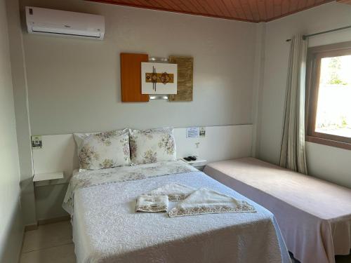 a bedroom with two beds and a window at Pousada Angela in Urubici