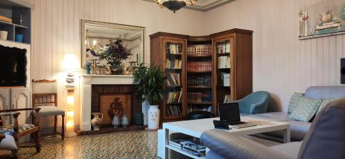 un salon avec un canapé et une table avec un ordinateur portable dans l'établissement La Villa de Domitille, à Châteaumur