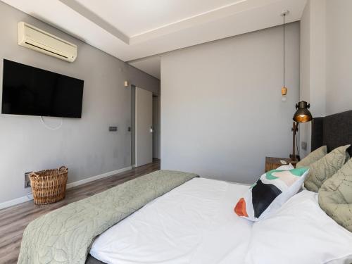 a bedroom with a bed and a tv on the wall at Walk in Hostel Faro Airport in Faro