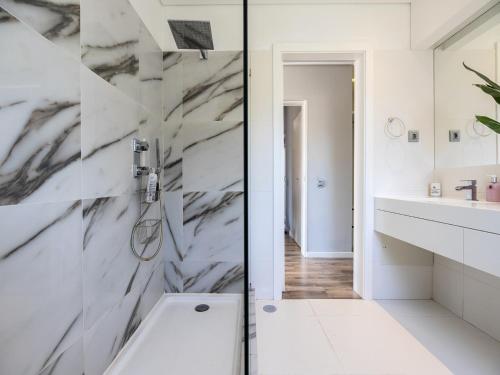 a white bathroom with a shower and a sink at Walk in Hostel Faro Airport in Faro