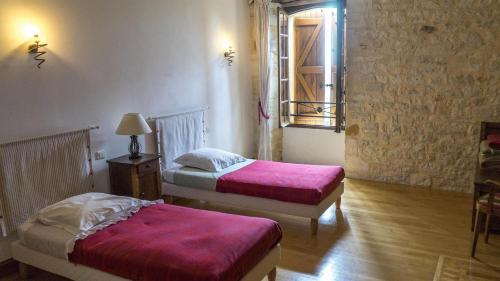 une chambre avec deux lits et une fenêtre dans l'établissement Gîte AYMARE 12 personnes, au Vigan