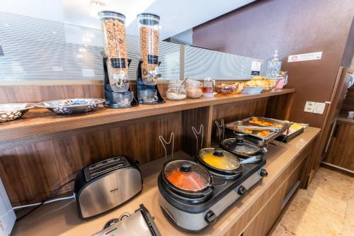 a kitchen with a stove with pots and pans at Athus Brasilia Hotel by Bsb Inn in Brasilia