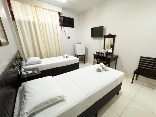 a room with two beds and a television in it at Athus Brasilia Hotel by Bsb Inn in Brasilia