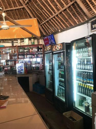 a store with two refrigerators and bottles of alcohol at The Beach House by Maasai in Mombasa