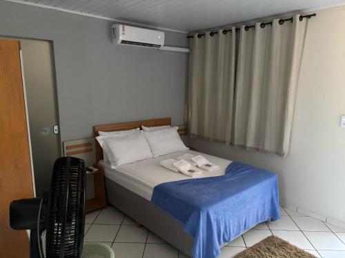 a bedroom with a bed with two towels on it at Pousada Vista das Pedras in Pancas