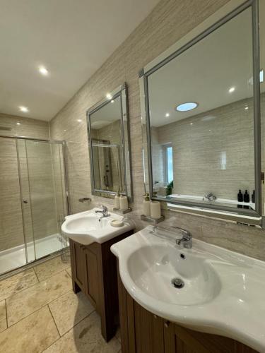 a bathroom with two sinks and a large mirror at Green Acres House in Horspath
