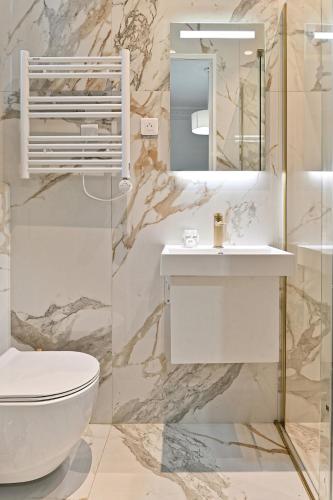 La salle de bains est pourvue d'un lavabo et d'un miroir. dans l'établissement Spacious and Bright Apartment, à Paris