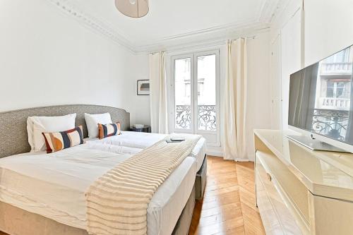 une chambre avec un grand lit et une télévision dans l'établissement Spacious and Bright Apartment, à Paris