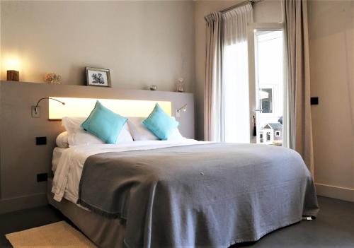 une chambre avec un grand lit avec des oreillers bleus dans l'établissement Villa Liza du Cap d'Antibes, à Antibes