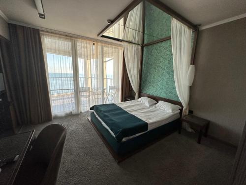 a hotel room with a bed and a large window at Regina Maria Spa Design Hotel in Balchik