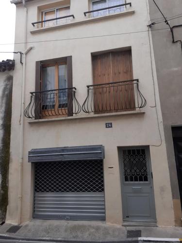 un bâtiment avec deux balcons, une porte et des fenêtres dans l'établissement N7 Demie chambre homme, à Béziers