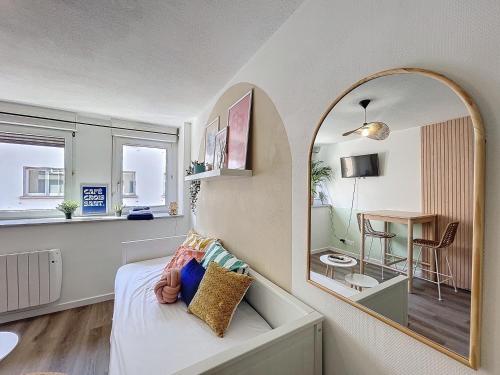 a bedroom with a mirror and a bed and a table at Le parthenon in Erstein