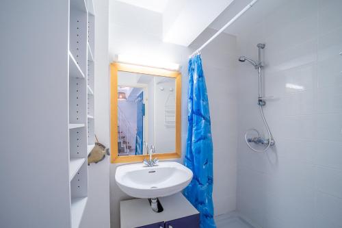 une salle de bain blanche avec un lavabo et un miroir dans l'établissement Les Goélettes - Vue mer et montagne plage à 100m, à Saint-Cyprien