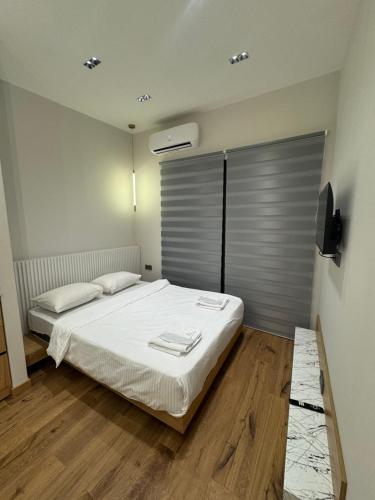 a bedroom with a white bed and a television at Aygestan plaza in Yerevan