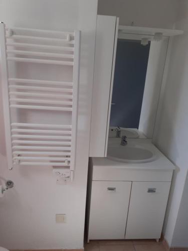 une salle de bain blanche avec un lavabo et un miroir dans l'établissement Sous Le Soleil Des Alpilles, à Mouriès