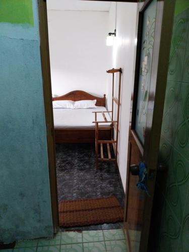 a small bedroom with a bed and a chair at Inuli Coco Hut in Kalutara
