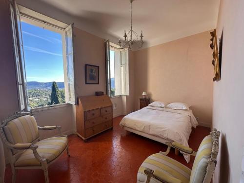une chambre avec un lit, une chaise et une fenêtre dans l'établissement Bastide provençale avec piscine, à Marseille